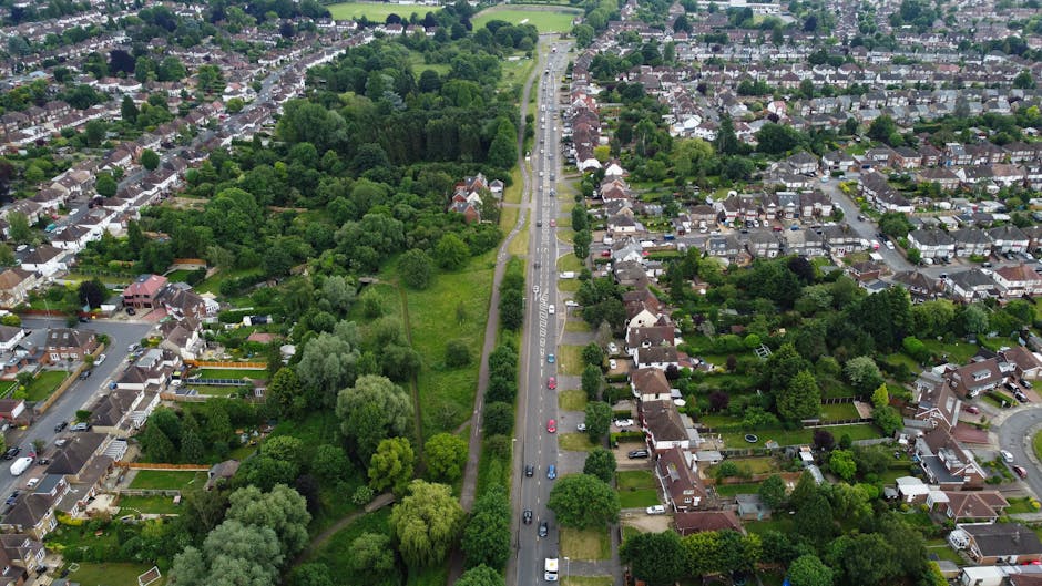 A view of a busy street scene near Friern Barnet, showing a double-decker bus with route number 43 heading towards Friern Barnet, parked on the right side of the street. In the background, pedestrians